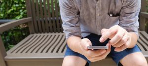 a person sat on a bench using a smartphone