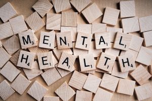 wooden Scrabble tiles spelling "mental health"